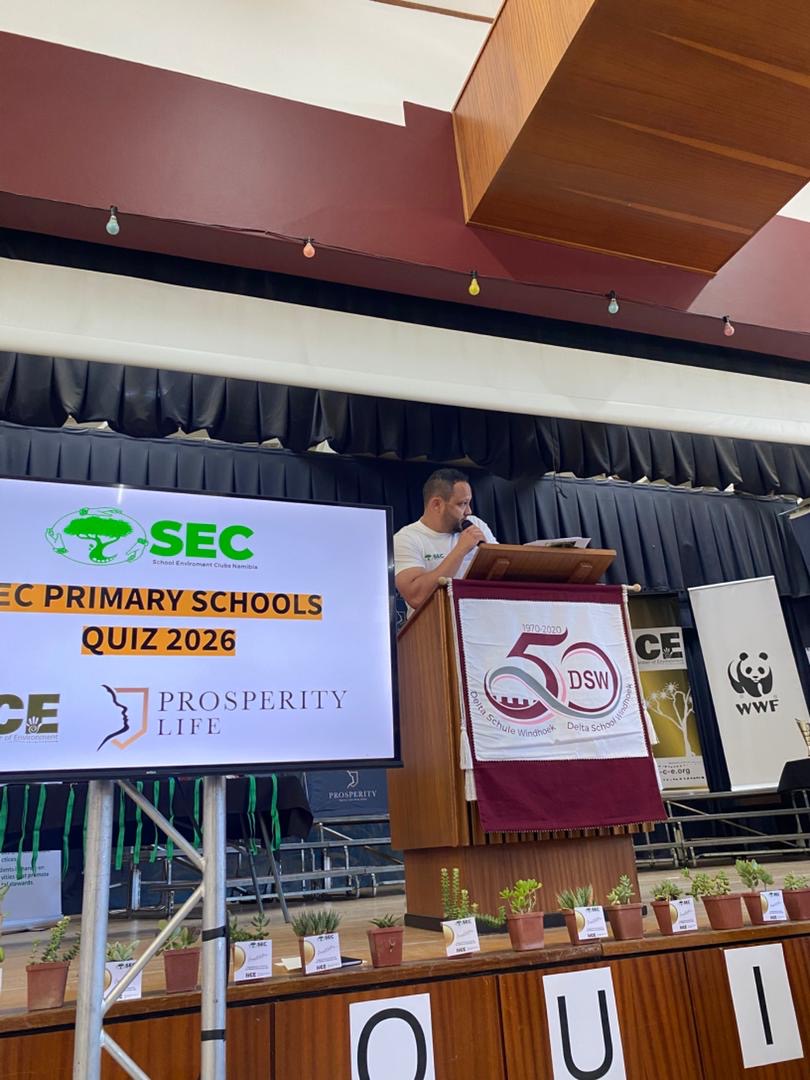 SEC Primary Schools Quiz 2026 title slide on stage, sponsored by NCE and Prosperity Life